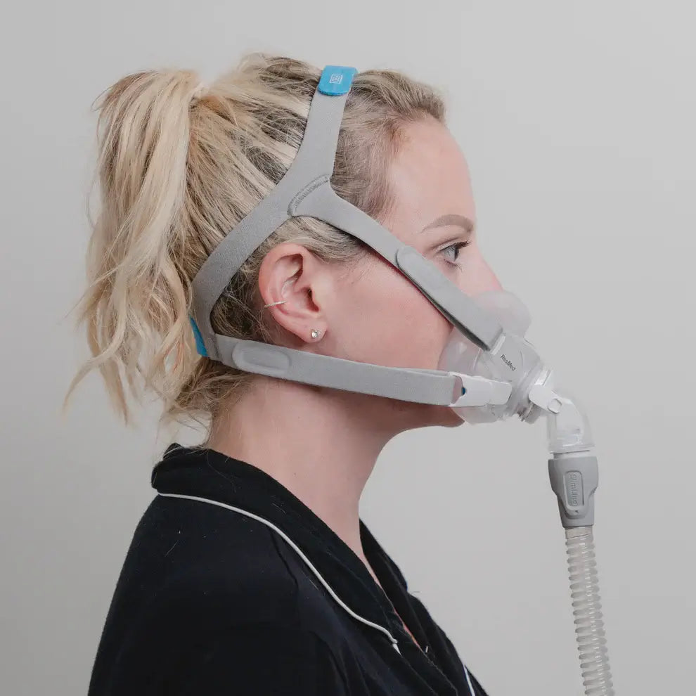 Side view of woman wearing ResMed AirFit F30 Full Face Hybrid Mask for CPAP therapy, featuring minimal contact fit for comfort.