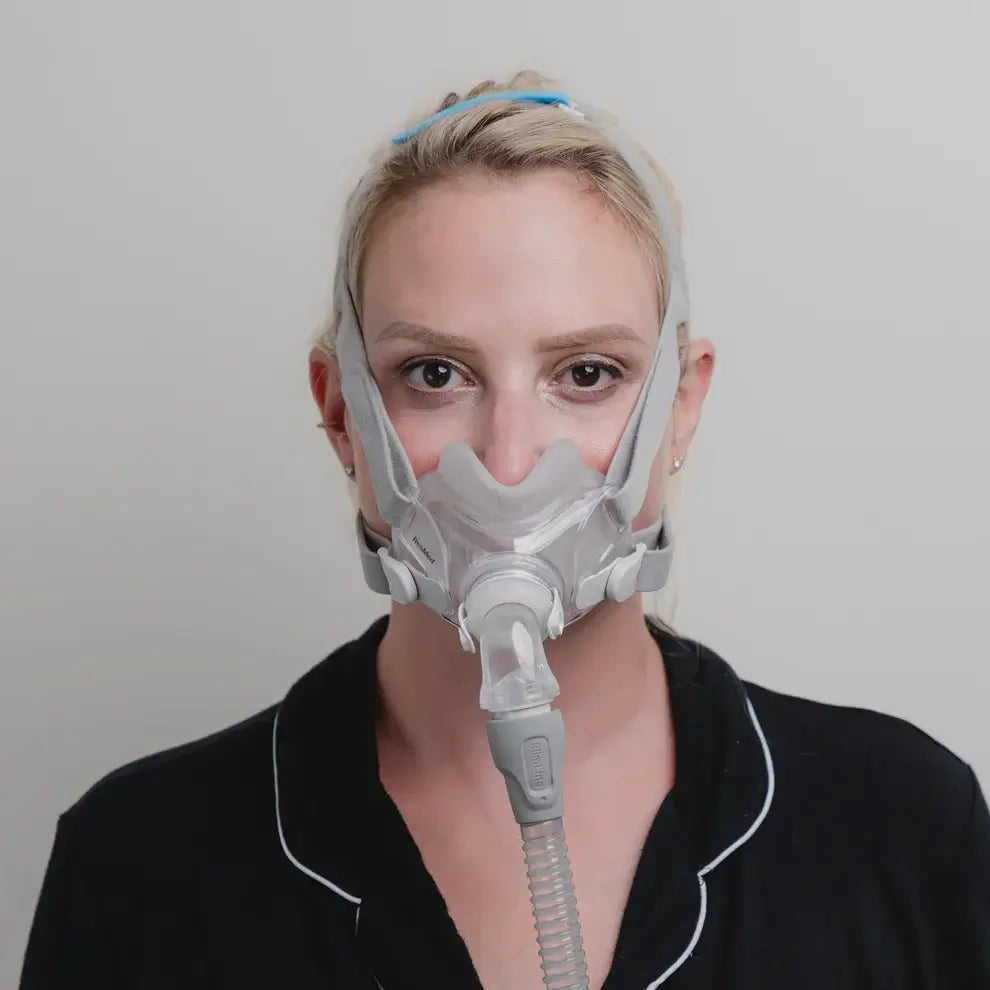 Woman wearing ResMed AirFit F30 Hybrid CPAP Mask with minimal contact fit for comfort and freedom during sleep therapy.