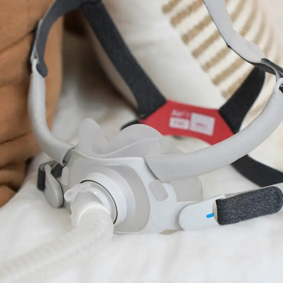 ResMed AirFit F40 Full Face Mask on bed, showcasing ultra-compact design and lightweight frame for comfortable sleep therapy.